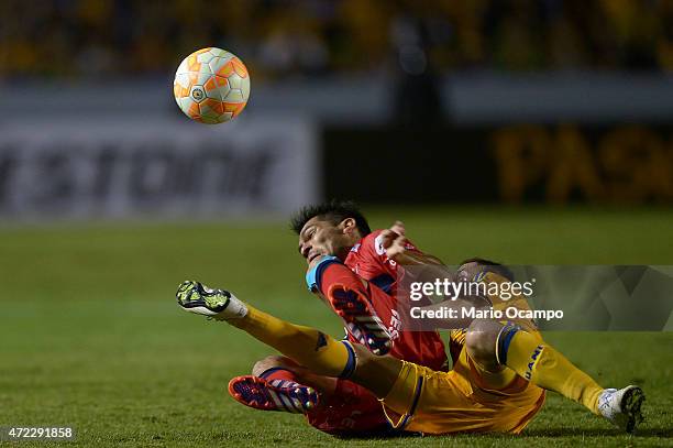 Israel Jimenez of Tigres and Alejandro Bejarano of Universitario de Sucre fall during a second leg match between Tigres and Universitario de Sucre as...