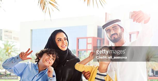 traditional emirati young family taking a selfie - fine art portrait stockfoto's en -beelden