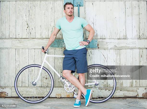 man posing with bicycle - men shorts stock pictures, royalty-free photos & images