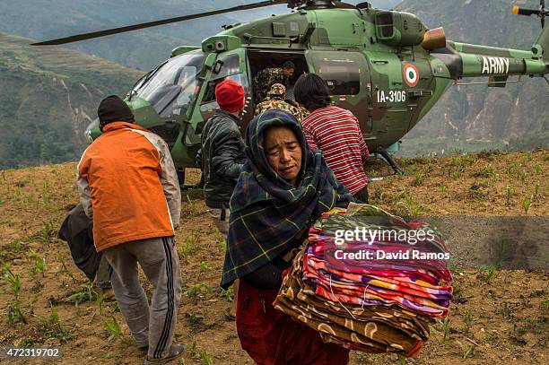 Nepalese villagers collect aid dropped by an Indian helicopter on May 6, 2015 in Gumda, Nepal. A major 7.9 earthquake hit Kathmandu mid-day on...