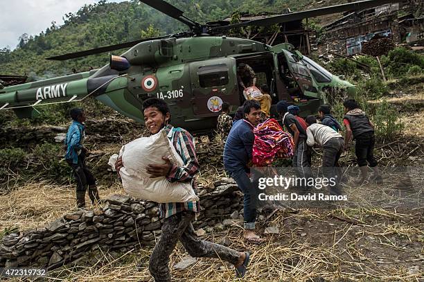 Nepalese villagers collect aid dropped by an Indian helicopter on May 6, 2015 in Hulchuk, Nepal. A major 7.9 earthquake hit Kathmandu mid-day on...