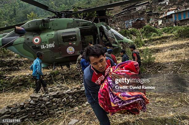 Nepalese villagers collect aid dropped by an Indian helicopter on May 6, 2015 in Hulchuk, Nepal. A major 7.9 earthquake hit Kathmandu mid-day on...