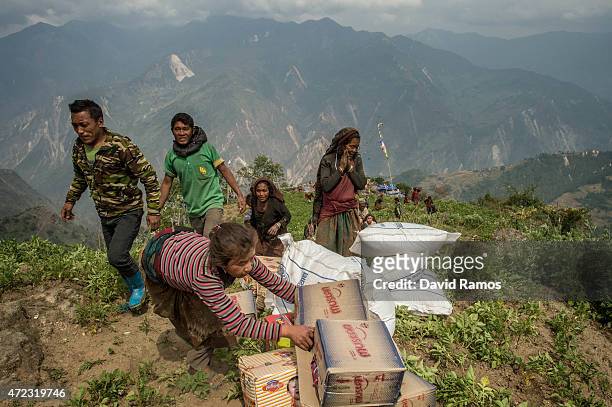 Nepalese villagers collect aid dropped by an Indian helicopter on May 6, 2015 in Khanigaun, Nepal. A major 7.9 earthquake hit Kathmandu mid-day on...