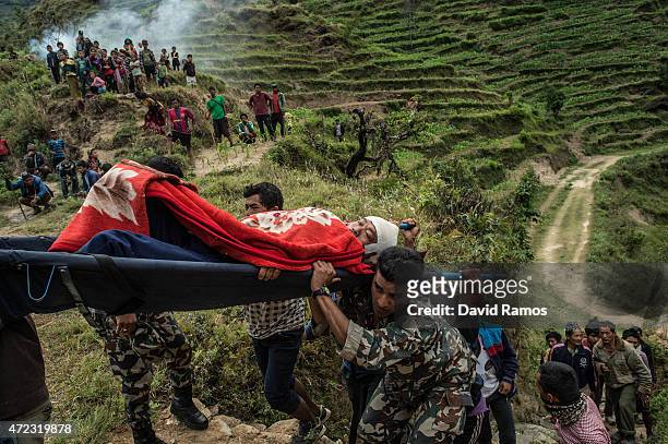 Buddy Prasad Grg, 45 is carried by villagers and Nepalese soldiers towards an Indian helicopter after being injured during an aftershock on May 6,...