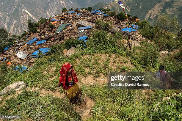 Nepalese vilagers climb up a hill to collect aid dropped by an Indian helicopter on May 6, 2015 in Khanigaun, Nepal. A major 7.9 earthquake hit...