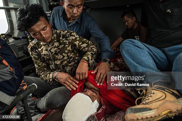 Villagers take care of Buddy Prasad Grg, 45 as they are evacuated by an Indian helicopter after being injured during an aftershock on May 6, 2015 in...