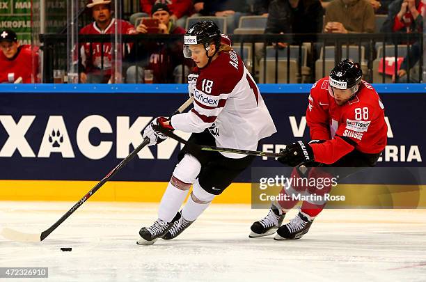 Kevin Romy of Switzerland and Rodrigo Abols of Latvia battle for the puck during the IIHF World Championship group A match between Switzerland and...