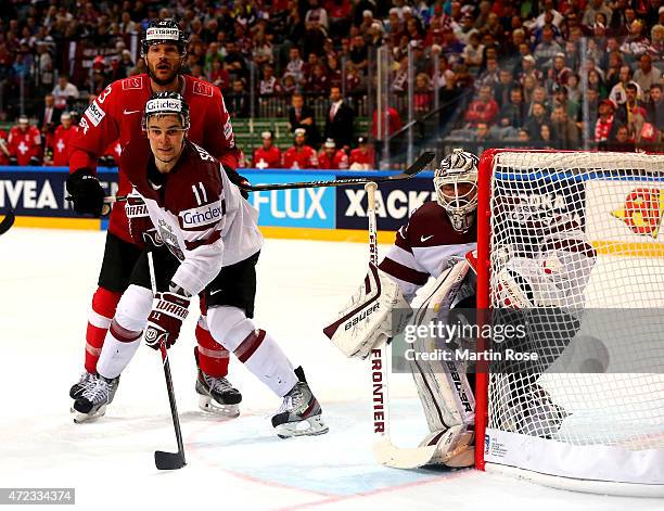 Matthias Bieber of Switzerland and Kristaps Sotnieks of Latvia battle for position in front of the net during the IIHF World Championship group A...