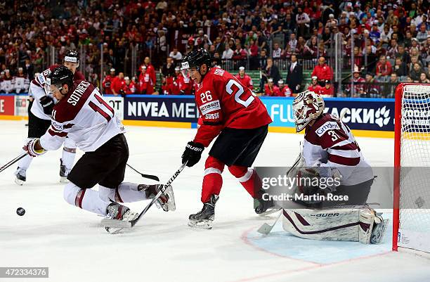 Reto Suri of Switzerland and Kristaps Sotnieks of Latvia battle for position in front of the net during the IIHF World Championship group A match...