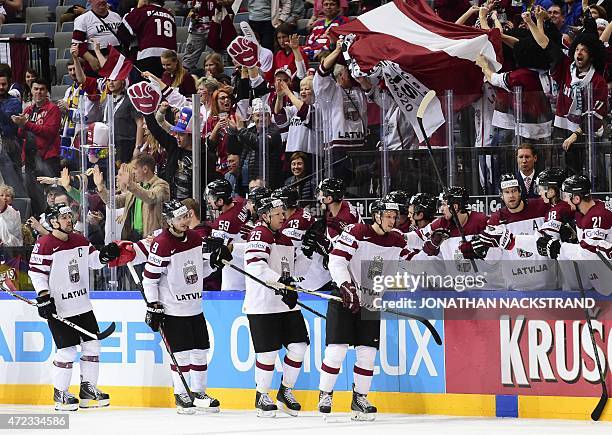 Forward Andris Dzerins of Latvia celebrates with his teammates after scoring a goal during the group A preliminary round match Switzerland vs Latvia...