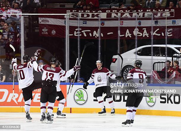 Forward Andris Dzerins of Latvia celebrates with his teammates after scoring a goal during the group A preliminary round match Switzerland vs Latvia...