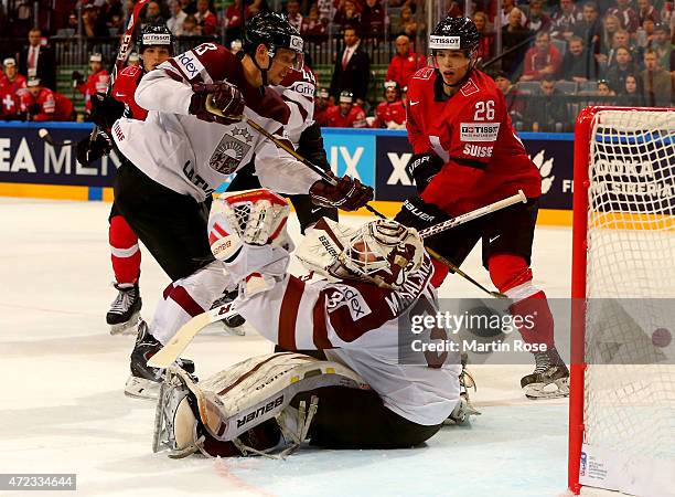 Edgars Masalskis , goaltender of Latvia makes a glove save during the IIHF World Championship group A match between Switzerland and Latvia at o2...