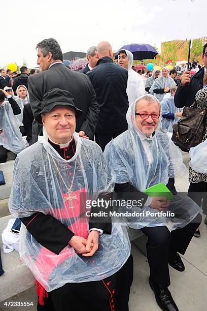 "The President of Lombardy Roberto Maroni and the Italian cardinal Gianfranco Ravasi wearing raincoats at the opening ceremony of Expo Milano...