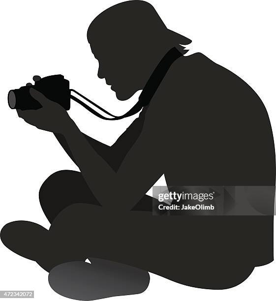 man sitting on ground with camera - dslr camera stock illustrations