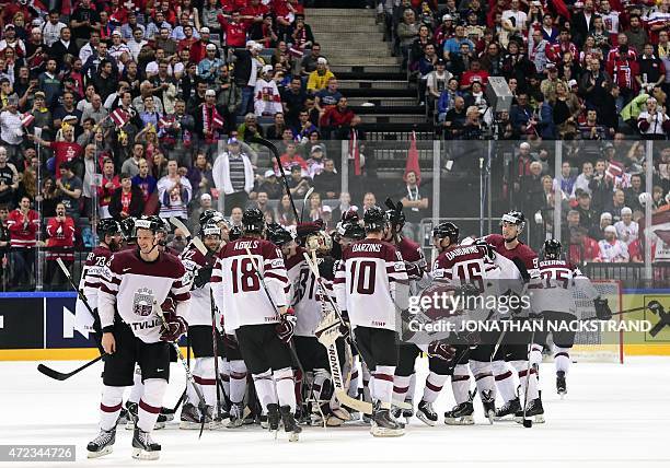 Forward Kaspars Daugavins of Latvia celebrates with his teammates after scoring a goal during overtime to win the group A preliminary round match...