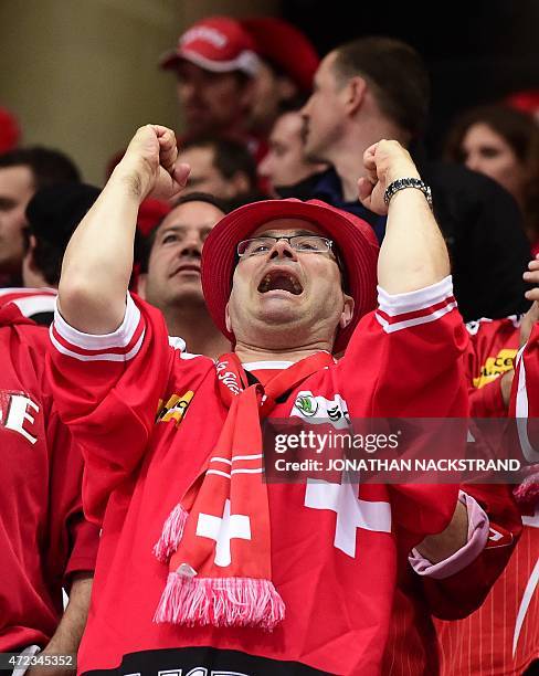 Swiss ice hockey supporter cheers his team during the group A preliminary round match Switzerland vs Latvia at the 2015 IIHF Ice Hockey World...