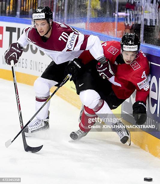 Defender Patrick Geering of Switzerland gets hit by Miks Indrassis of Latvia during the group A preliminary round match Switzerland vs Latvia at the...