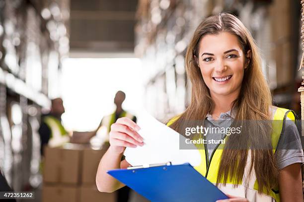 junge weibliche lagerhalle, die ihre lieferungen - warehouse worker stock-fotos und bilder