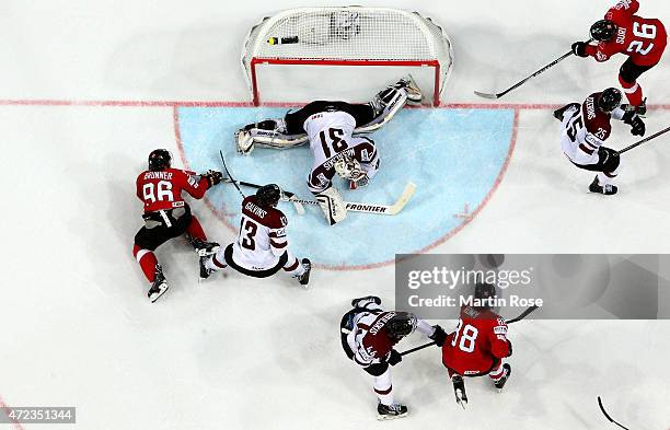 Edgars Masalskis , goaltender of Latvia makes a save on Damien Brunner of Switzerland during the IIHF World Championship group A match between...