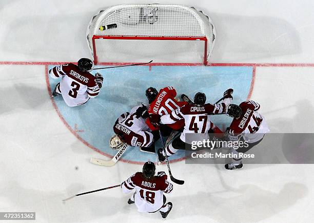 Edgars Masalskis , goaltender of Latvia makes a save on Denis Hollenstein of Switzerland during the IIHF World Championship group A match between...