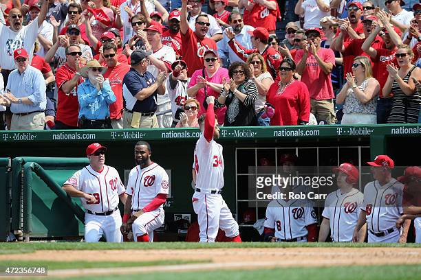 Bryce Harper of the Washington Nationals comes out of the dugout to acknowledge the crowd after hitting a solo home run against the Miami Marlins in...