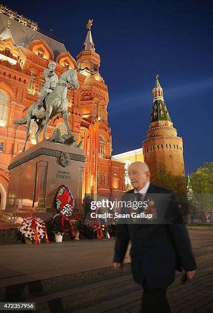 An elderly man wearing war medals walks past a statue of World War II Russian General Georgy Zhukov, who led Soviet Red Army forces in the final push...