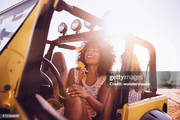 happy afro girl eating ice cream at the beach - african girls on beach stock pictures, royalty-free photos & images