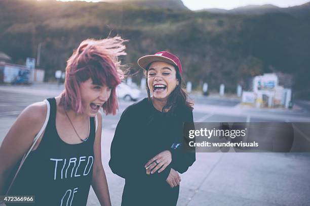 grunge mädchen lachen zusammen in einem parkplatz - friend mischief stock-fotos und bilder