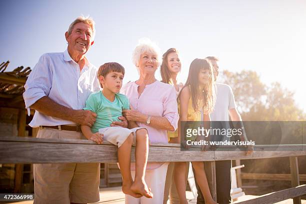 großeltern mit ihrer familie im freien mit sonne flare - sun flare couple stock-fotos und bilder