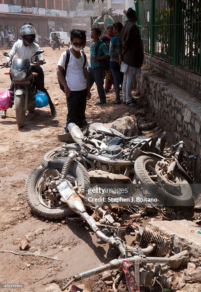 People look at crushed motorcycles at Dharahara tower. A...