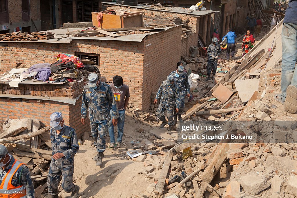 Nepali Military Police walk between damaged homes in Khokana...