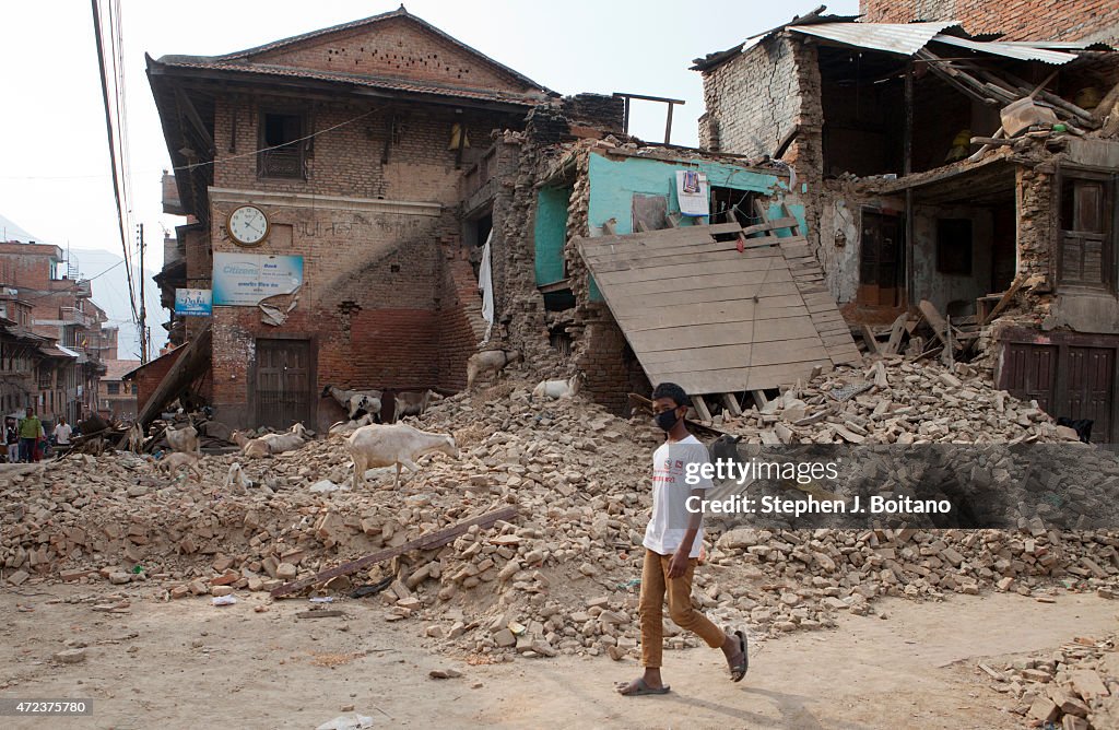 A young man walks past a damaged home in Khokana. A major 7.