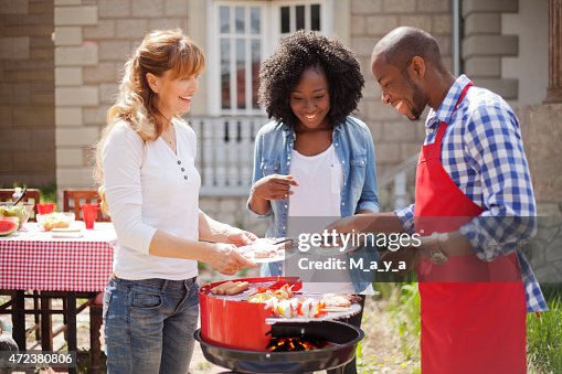 Friends enjoying a barbecue on a sunny day Friends enjoying a barbecue on a sunny day