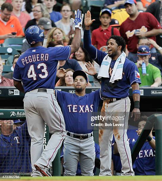 Carlos Peguero of the Texas Rangers receives a high five from Elvis Andrus after hitting a home run in the second inning against the Houston Astros...