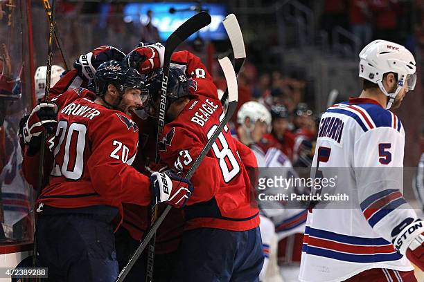 Troy Brouwer of the Washington Capitals and teammates surround Andre Burakovsky after he scored the game-winning goal against the New York Rangers...