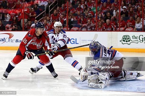 Andre Burakovsky of the Washington Capitals scores the game-winning goal in front of Ryan McDonagh and goalie Henrik Lundqvist of the New York...