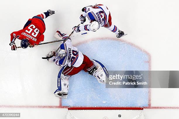 Andre Burakovsky of the Washington Capitals scores the game-winning goal in front of Ryan McDonagh and goalie Henrik Lundqvist of the New York...