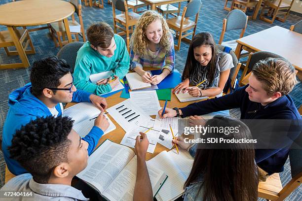 diversas estudio grupo de adolescentes estudiando juntos en una biblioteca - boy and girl talking fotografías e imágenes de stock