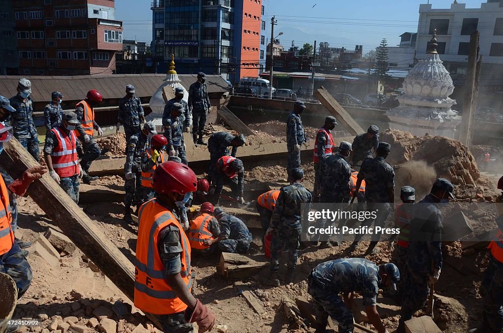 Volunteers and army remove debris at a temple at Thapathali...