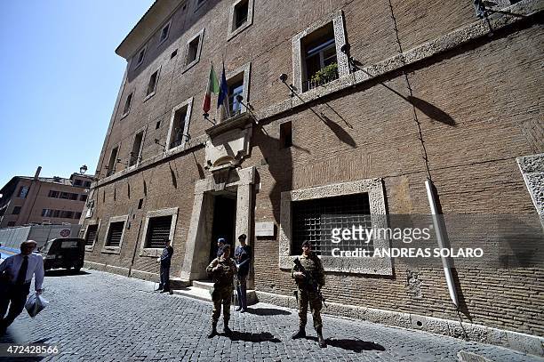 Policemen and soldiers stand guard outside the Italian national Anti-mafia services headquarters on May 7, 2015 in Rome. AFP PHOTO / ANDREAS SOLARO