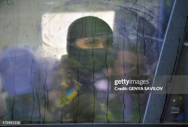 Volunteer of the Ukrainian Azov regiment looks through a bus window before a departure to the east of Ukraine after taking part in trainings at a...