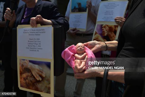 An anti-abortion activist holds a model of a fetus during a protest outside of the Longworth House Office Building on Capitol Hill in Washington, DC...