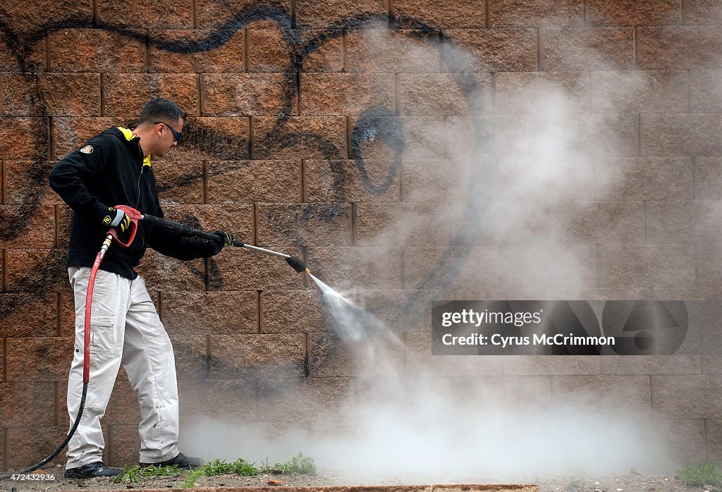 Graffiti technician for Adams County  Joaquin Flores cleans a wall.