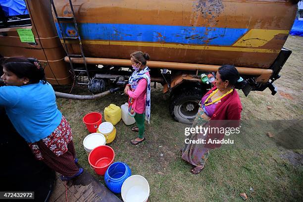 Nepalese women wait to fill buckets with water at an earthquake victim camp site in Kathmandu, Nepal on May 7, 2015. The number of the dead in the...