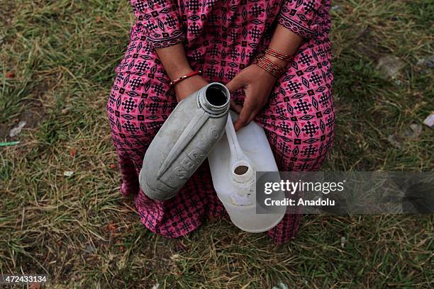 Nepalese holding empty bottles waits to fill bottles with water at an earthquake victim camp site in Kathmandu, Nepal on May 7, 2015. The number of...