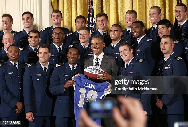President Barack Obama is presented with a football and a jersey after presenting the Commander-in-Chief trophy to the United States Air Force...