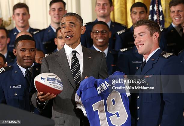 President Barack Obama is presented with a football and a jersey after presenting the Commander-in-Chief trophy to the United States Air Force...