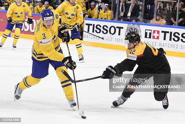 Forward Yasin Ehliz of Germany tries to stop a shot from defender John Klingberg of Sweden during the group A preliminary round match Sweden vs...