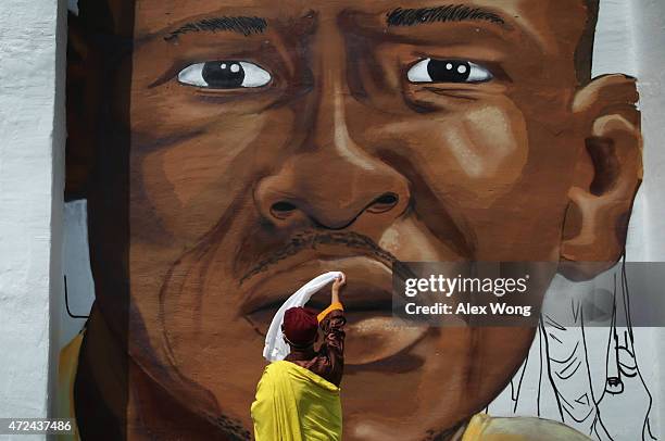 The 12th Gyalwang Drukpa, the Buddhist leader of South Asia , waves a scarf in front of a mural of Freddie Gray as he tours the Sandtown neighborhood...