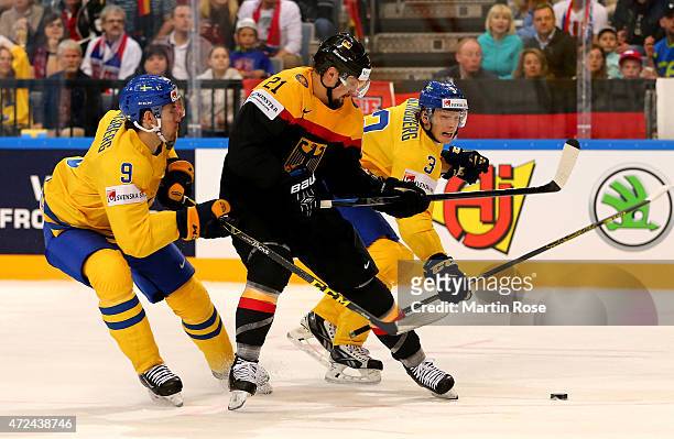 Filip Forsberg and John Klingberg of Sweden and Nicolas Kramer of Germany battle for the puck during the IIHF World Championship group A match...